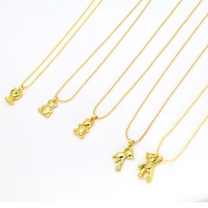 Detailed view of five gold bear and cat pendant necklaces with sparkling bead chains