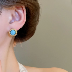 Close-up of vintage style 18k gold plated stud earrings with turquoise stones on model
