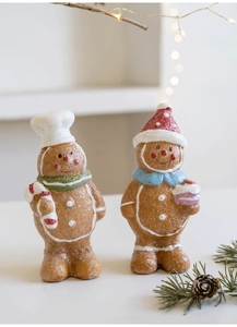 Detailed view of two festive resin gingerbread man ornaments with sparkling frost finish