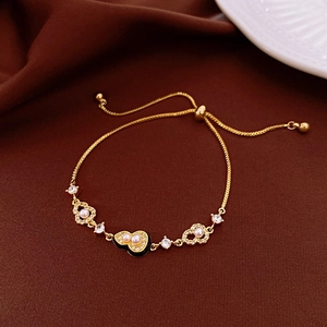 Gold plated bracelet with pearl gourd charm on a luxury dark red velvet background