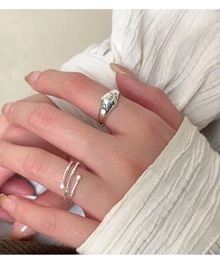 Macro detail of S925 silver irregular bamboo joint ring and engraved band on hand