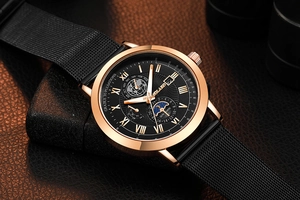 Macro detail of rose gold watch case and black mesh steel strap on leather background