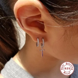 Detail of S925 sterling silver dagger earrings with cubic zirconia on model's ear