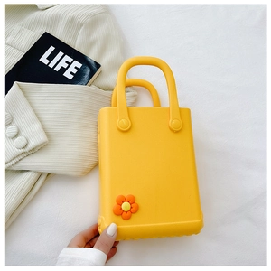 Detailaufnahme einer gelben EVA-Strandtasche mit süßer orangefarbener Blumenverzierung