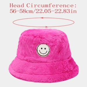 Detail of hot pink plush bucket hat with smiley face patch and thick faux fur texture