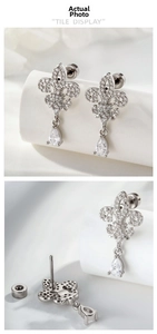 Macro view of fleur-de-lis earrings with micro-set zircon and pear-cut drop stones