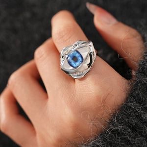 Detailed macro shot of irregular fluid silver ring featuring a realistic blue evil eye