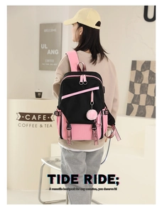 Black and pink patchwork backpack shown in a cozy cafe setting being worn by a model