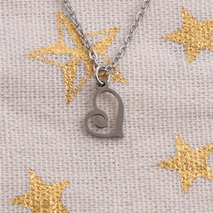 Silver stainless steel necklace with spiral hollow heart pendant on textured fabric