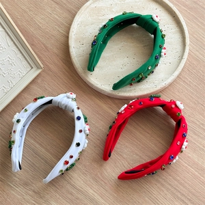 Detailed top view of red, white and green knotted headbands with colorful rhinestones