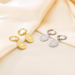 Detailed view of gold and silver sun moon oval pendants on champagne satin background