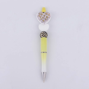 Detail of DIY beadable pen with heart shape, daisy charm, and leopard print beads