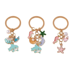 Golden ocean series keychains with enamel shark, shell, seahorse, and pearl charms