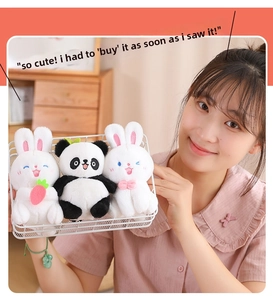 Three plush bunny and panda dolls in a white wire basket held by a person in a cozy setting