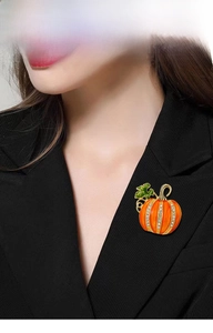 Detail of orange enamel pumpkin brooch with rhinestones on black suit lapel
