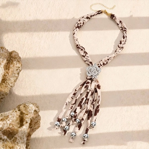 Détail macro du pendentif fleur en tissu avec strass et pompons à perles argentées