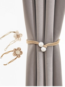 Close-up of handmade jute flower curtain tiebacks with woven rope and pearl accents