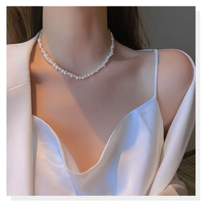 Close-up of irregular baroque freshwater pearl necklace worn by a fashion model