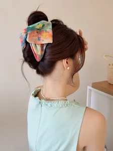 Vue détaillée d'une pince à cheveux avec nœud en tissu tie-dye coloré pour femmes