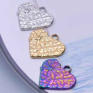 Détail de pendentifs en forme de cœur en acier inoxydable avec motif floral et martelé