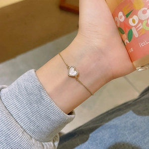 Vista dettagliata del bracciale a cuore con intarsio in madreperla bianca e zirconi