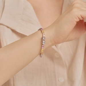 Detail of multi-color zircon tennis bracelet on wrist with a secure fold-over clasp