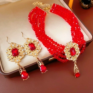 Detailed view of vintage multi-layered red bead necklace and earrings in a silk jewelry box