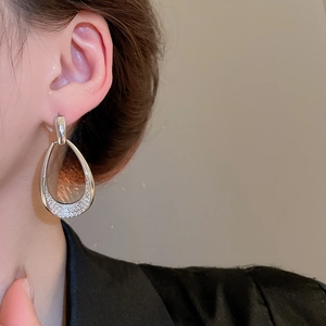 Detail showing elegant silver water drop earrings with zircon inlay worn by a model