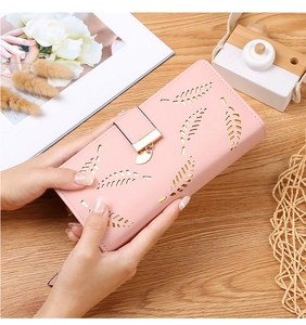 Close-up of pink long wallet featuring laser-cut leaf design and gold metal pendant