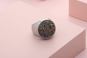 Macro shot of polished stainless steel ring with a large iridescent druzy circular stone