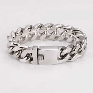 Macro detail of silver cuban link bracelet with polished clasp on white background