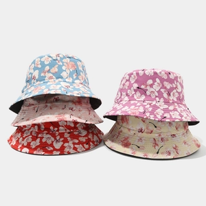 Detail showing five floral bucket hats in blue, pink, red, purple, and beige cotton fabric
