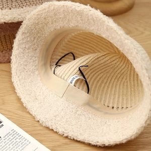 Detailed view of beige knit bucket hat with soft plush fleece and adjustable inner cord