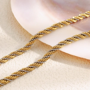 Macro detail of intertwined gold and silver twisted chain necklace with metallic texture