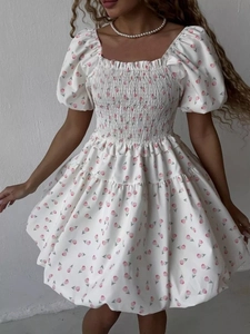Detail of square neckline with smocking and pink tulip print on white summer dress
