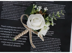 Detail of white artificial rose boutonniere with eucalyptus leaves and jute twine wrap