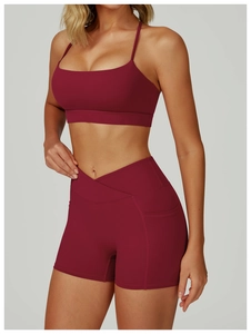 Detail of burgundy yoga set featuring V-cross high waist shorts with side pockets