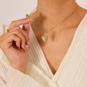 Detail of gold heart pendant necklace with shimmering crystals on elegant model