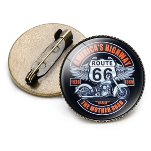 Vintage Route 66 glass dome brooch with bronze metal base and pin back on white background