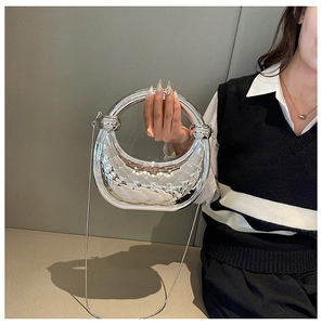 Detail of silver crescent acrylic bag with quilted metal finish and round handle