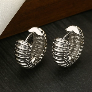 Close-up of silver-tone ribbed hoop earrings with a stacked bead design and metallic luster