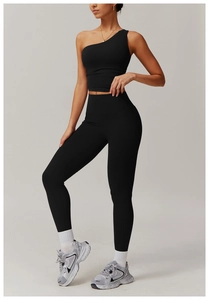 Détail d'un ensemble de yoga noir avec haut asymétrique et legging à taille haute