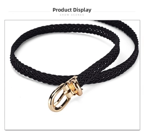 Detailed view of black woven skinny belt with high-gloss gold horseshoe buckle for dresses