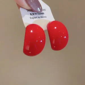 Polished dark red waterdrop acrylic stud earrings on a white display card