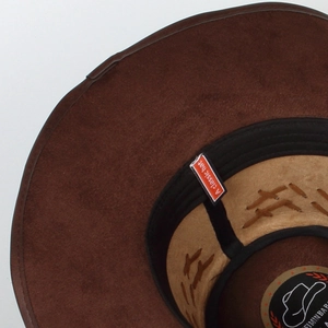 Inside detail of brown suede western cowboy hat with black sweatband and red woven label