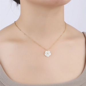 Close-up of gold-plated O-chain with white shell flower pendant on a model neck