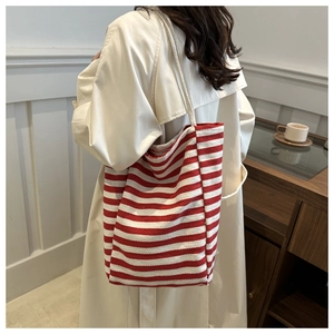Detail of red and white striped canvas tote bag showing the textured weave and rope handle