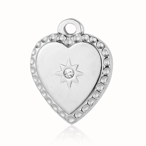 Detailed view of silver heart pendant with starburst texture and small clear stone inlay