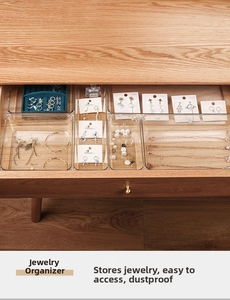 Close-up of clear acrylic jewelry organizers with multiple dividers in a wooden drawer