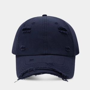 Detailed view of the distressed texture and ripped holes on dark blue baseball cap